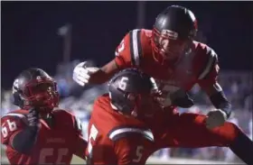  ?? GENE WALSH — DIGITAL FIRST MEDIA ?? Upper Dublin’s (66) Bryan Derr and (13) Jason Scott embrace (5) Dylan Zlotnikoff after his second-quarter touchdown reception against West Chester Rustin in the PIAA 5A semi-final at Upper Dublin.