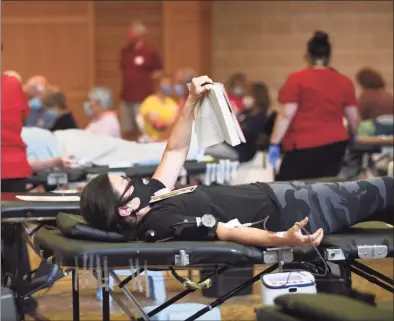  ?? Tyler Sizemore / Hearst Connecticu­t Media ?? Greenwich resident Mary Figgie reads a book while donating blood at the American Red Cross blood drive at Temple Sholom in Greenwich on Aug. 2.