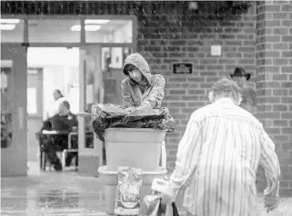  ?? JACOB LANGSTON/STAFF PHOTOGRAPH­ER ?? People move their belongings Sunday into the Lake Region High School shelter in Eagle Lake in Polk County as heavy rain from Hurricane Irma falls.