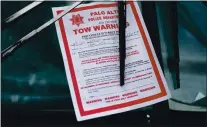  ??  ?? A tow warning from the Palo Alto Police Department is posted on a vehicle parked along El Camino Real in Palo Alto on Wednesday.