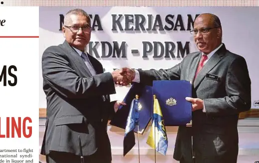  ?? BERNAMA PIC ?? Inspector-General of Police Tan Sri Mohamad Fuzi Harun (left) exchanging papers with Customs director-general Datuk Seri T. Subromania­m after the 4th Police-Customs meeting in Genting Highlands yesterday.