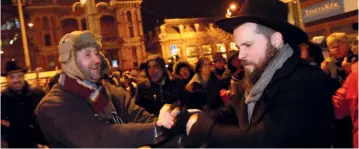  ?? (Reuters) ?? MEMBERS OF Hungary’s Jewish community gather to celebrate Hanukka and to light the first candle on the menorah in downtown Budapest.