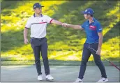  ?? CHASE STEVENS — LAS VEGAS REVIEW-JOURNAL VIA AP ?? Xander Schauffele, left, fist bumps with Viktor Hovland after finishing the second round of the CJ Cup golf tournament at the Shadow Creek Golf Course, Friday, in North Las Vegas.