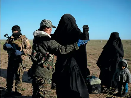  ?? AP ?? A woman is frisked by a Syrian Democratic Forces fighter at a screening area in the desert outside Baghouz, Syria, after being evacuated yesterday from the last territory held by Islamic State militants.