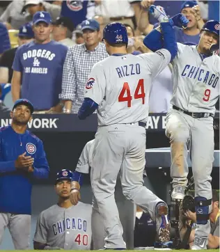  ??  ?? Javy Baez ( 9) congratula­tes Anthony Rizzo on his homer in the fifth, a rare offensive feat from Rizzo