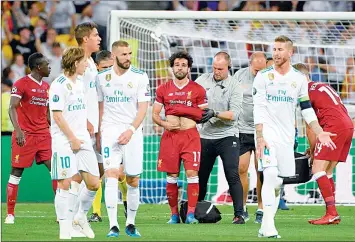  ??  ?? La estrella del Liverpool, Mohamed Salah (centro), debió salir de la final de la Liga de Campeones de Europa el sábado tras ser derribado por Sergio Ramos (derecha) ■ Foto Afp