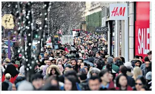  ??  ?? A crowd of shoppers on London’s Oxford Street on Boxing Day. But across the country, fewer bargain hunters headed to the shops for the sales this year