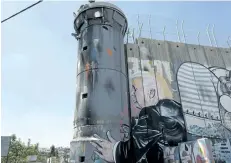  ?? NASSER NASSER/THE ASSOCIATED PRESS ?? A mural resembling the work of elusive artist Banksy depicts U.S. President Donald Trump kissing an Israeli army watchtower in the West Bank city of Bethlehem.
