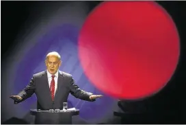  ?? PHOTOS BY MARKUS SCHREIBER/ASSOCIATED PRESS ?? In this photo taken with a red television camera control light in the foreground, Israeli Prime Minister Benjamin Netanyahu addresses a news conference in Berlin on Wednesday.