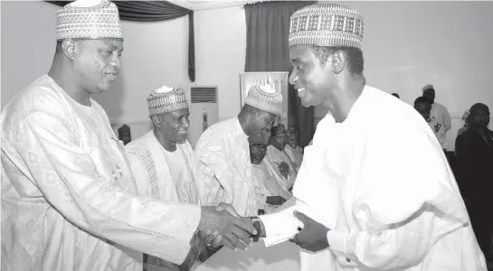  ??  ?? Gov. Ibrahim Gaidam of Yobe (left) congratula­ting the newly elected State Chairman of the All Progressiv­es Congress (APC) Alhaji Mai Mala Buni, shortly after the inaugurati­on of the APC State Executives by the chairman of the party’s Congress...