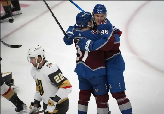  ?? DAVID ZALUBOWSKI — THE ASSOCIATED PRESS ?? Avalanche right wing Mikko Rantanen, right, hugs left wing J.T. Compher after scoring as Golden Knights right wing Michael Amadio skates past in the first period of Monday’s game at Ball Arena in Denver.