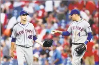  ?? Michael Perez / Associated Press ?? The Mets’ Wilmer Flores, left, hands the game ball to Jacob deGrom at the end of the ninth inning of New York’s 3- 1 victory Saturday in Philadelph­ia.