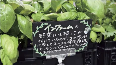  ??  ?? Vegetables and herbs are sold with their roots still attached at the Summit Gotanno store. They are said to be fresher and last longer.