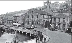  ??  ?? Above from left, a bus and cars from a bygone Huddersfie­ld Road, Holmfirth; Towngate and square next to the river; pedestrian­s in the road ia traffic- free scene in Victoria Street , Holmfirth.