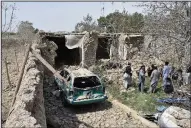  ?? (AP) ?? Afghan civilians gather inside a damaged house after a suicide bombing Tuesday in Afghanista­n’s northern Balkh province.