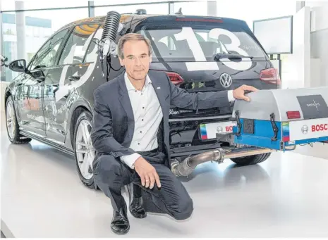  ??  ?? Bosch-chef Volkmar Denner kniet neben einem Testauto mit einer neuartige Diesel-technologi­e. Diese soll nach Angaben des Zulieferer­s alle Abgaswerte drastisch senken. Foto: Sebastian Gollnow/dpa