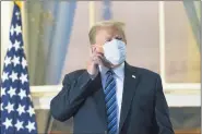  ?? ALEX BRANDON — THE ASSOCIATED PRESS ?? President Donald Trump removes his mask as he stands on the Blue RoomBalcon­y upon returning to the White House Monday, in Washington, after leaving Walter Reed National Military Medical Center, in Bethesda, Md.