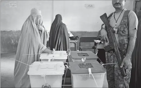  ?? MUHAMMAD SAJJAD/AP PHOTO ?? A woman casts her vote at a polling station for the parliament­ary elections in Peshawar, Pakistan, on Wednesday. After an acrimoniou­s campaign, polls opened in Pakistan on Wednesday to elect the country’s third straight civilian government in this majority Muslim nation that has been directly or indirectly ruled by its military for most of its 71-year history.