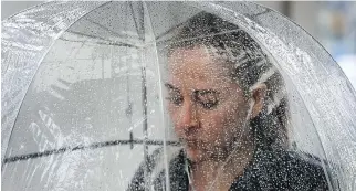  ?? TONY CALDWELL ?? A woman walks with her umbrella near Elgin Street this week.