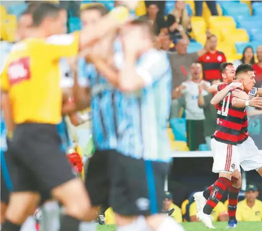  ??  ?? Uribe é abraçado por Réver e Pará depois de marcar o primeiro gol do Flamengo