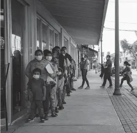  ?? Veronica G. Cardenas / Bloomberg ?? Asylum seekers arrive at a COVID-19 testing site after being processed by U.S. immigratio­n officials Wednesday in McAllen. A federal judge temporaril­y blocked the governor’s order to stop NGOs from transporti­ng migrants.