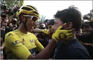  ?? CHRISTOPHE ENA — THE ASSOCIATED PRESS ?? Egan Bernal wearing the overall leader’s yellow jersey embraces a relative after the twenty-first stage of the Tour de France July 28.