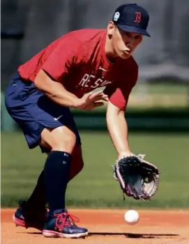  ?? JIM DAVIS/GLOBE STAFF ?? New Red Sox outfielder Masataka Yoshida tries his hand at some grounders in the infield (above), and Chris Sale puts smiles on the faces of fans at Fenway South (below).