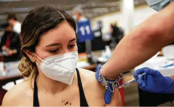  ?? Jessica Phelps / Staff photograph­er ?? Briana T., 21, receives her first dose of the COVID-19 vaccine on the first day appointmen­ts were open to all Texans over the age of 16.