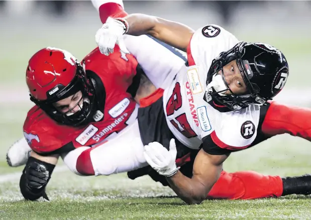  ?? — THE CANADIAN PRESS ?? Ottawa Redblacks wide receiver Diontae Spencer, right, fumbles the ball while tangled with Calgary Stampeders linebacker Riley Jones during Sunday’s Grey Cup. There’s usually less falling down in CFL games, Mexican first-time viewers might need to be told.