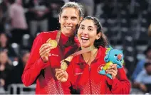  ?? WILLIAM WEST/AFP/GETTY IMAGES ?? Canada’s Sarah Pavan and Melissa Humana-Paredes celebrate with their gold medals after the women’s beach volleyball final Thursday at the Commonweal­th Games in Australia.