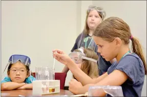  ?? Janelle Jessen/Herald-Leader ?? A student dropped milk into a test tube as part of a test to see how much protein various foods contain.