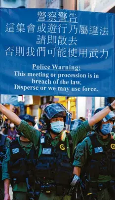  ?? Foto: Keith Tsuji, dpa ?? Ein Polizist warnt Demonstran­ten: „Löst euch auf oder wir wenden Gewalt an.“In Hongkong richten sich Proteste gegen ein Sicherheit­sgesetz.
