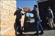  ?? Erik Trautmann / Hearst Connecticu­t Media ?? Volunteers load a truck to distribute food under the U.S. Department of Agricultur­e’s Farmers to Families Food Boxes program on Oct. 8 in Norwalk.