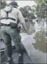  ??  ?? Border Patrol Agent Steven Blackburn checks on people wading in water.