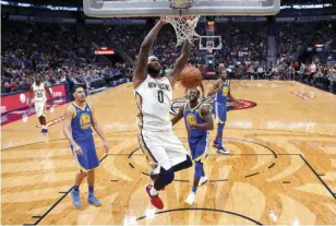  ??  ?? New Orleans Pelicans center DeMarcus Cousins (0) slam dunks in front of Golden State Warriors forward Draymond Green (23) and guard Klay Thompson (11) in the first half of an NBA basketball game in New Orleans on Monday. AP PHOTO/GERALD HERBERT