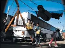  ??  ?? Children play after class in the converted bus in Tijuana.