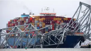  ?? (Mike Segar/Reuters) ?? THE ‘DALI’ container ship that crashed into the Francis Scott Key Bridge in Baltimore floats among the mangled debris of the bridge yesterday.