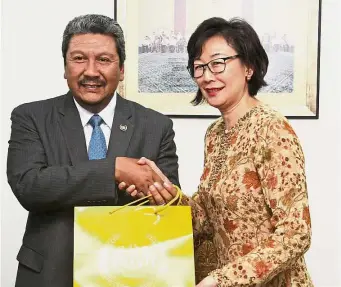  ??  ?? Generous contributi­on: Wan Ahmad Dahlan presenting the donation to Goh at Istana Negara.