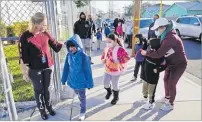  ?? Picture: AP ?? Assistant Principal Janette Van Gelderen, left, welcomes students at Newhall Elementary in Santa Clarita, California.