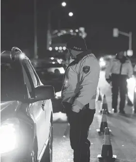  ?? JAMES PARK FOR NATIONAL POST ?? An Ottawa police officer conducts a RIDE check that screens for alcohol and cannabis on Thursday, the day after Canada legalized recreation­al marijuana use.