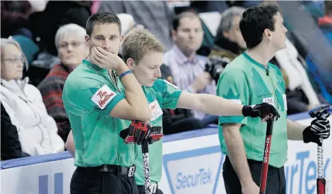  ?? JOHN WOODS/THE CANADIAN PRESS ?? From left, skip John Morris and teammates Tyrel Griffith and Rick Sawatsky wait for a shot from Kevin Martin’s rink Friday.