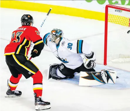  ?? AL CHAREST ?? Flames centre Sean Monahan scores on San Jose goalie Aaron Dell, who split time in net with Antoine Bibeau, during the Flames’ 7-5 pre-season victory Tuesday at the Saddledome. Sam Bennett scored go-ahead goal with the game tied 5-5.