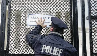  ?? MARIAM ZUHAIB/AP ?? A U.S. Capitol Police officer on Friday hangs a sign on the temporary anti-scaling fence that was installed surroundin­g the U.S. Supreme Court in Washington. The leak last week of a justice’s draft opinion on abortion has ratcheted up protests and threats from opposing advocates.