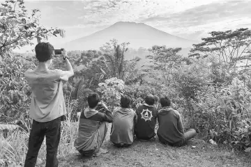  ??  ?? People look at Mount Agung in Karangasem. — AFP photo