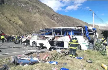  ??  ?? Photo released by the Fire Brigade of Quito shows firefighte­rs working at the scene of an accident where a bus crashed into another vehicle, in the road between Pifo and Papallacta, 30 kilometres east of Quito. — AFP photo