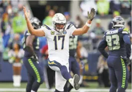  ?? Scott Eklund / Associated Press ?? Chargers quarterbac­k Philip Rivers, making his 200th consecutiv­e start, kicks up his heel as he celebrates a touchdown in Seattle.