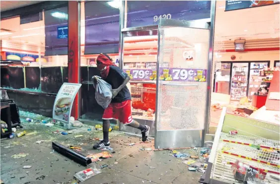  ?? Picture / AP ?? Shops were looted and cars vandalised after 18-year-old Michael Brown was killed in a scuffle with police.