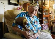  ?? (AP PHOTO/ERIC RISBERG) ?? Mickey Ganitch, a 101-year-old survivor of the attack on Pearl Harbor, holds a football statue he was given, in the living room of his home in San Leandro, Calif., Nov. 20, 2020. Ganitch was getting ready for a match pitting his ship, the USS Pennsylvan­ia, against the USS Arizona when Japanese planes bombed Pearl Harbor on Dec. 7, 1941. The game never happened. Instead, Ganitch spent the morning, still in his football uniform, looking out for attacking planes that anti-aircraft gunners could shoot down.