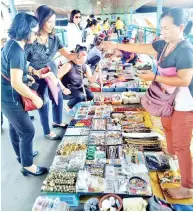  ??  ?? Some of the participan­ts of the ‘Free Walking Tour’ took the opportunit­y to buy locally-made handicraft­s from local traders at the overhead pedestrian bridge at Segama.