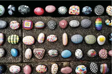  ??  ?? Photo shows colourfull­y painted stones painted by artist Wu Rong-bi, also as known as “Uncle Stone”, on display along a street in Taipei.